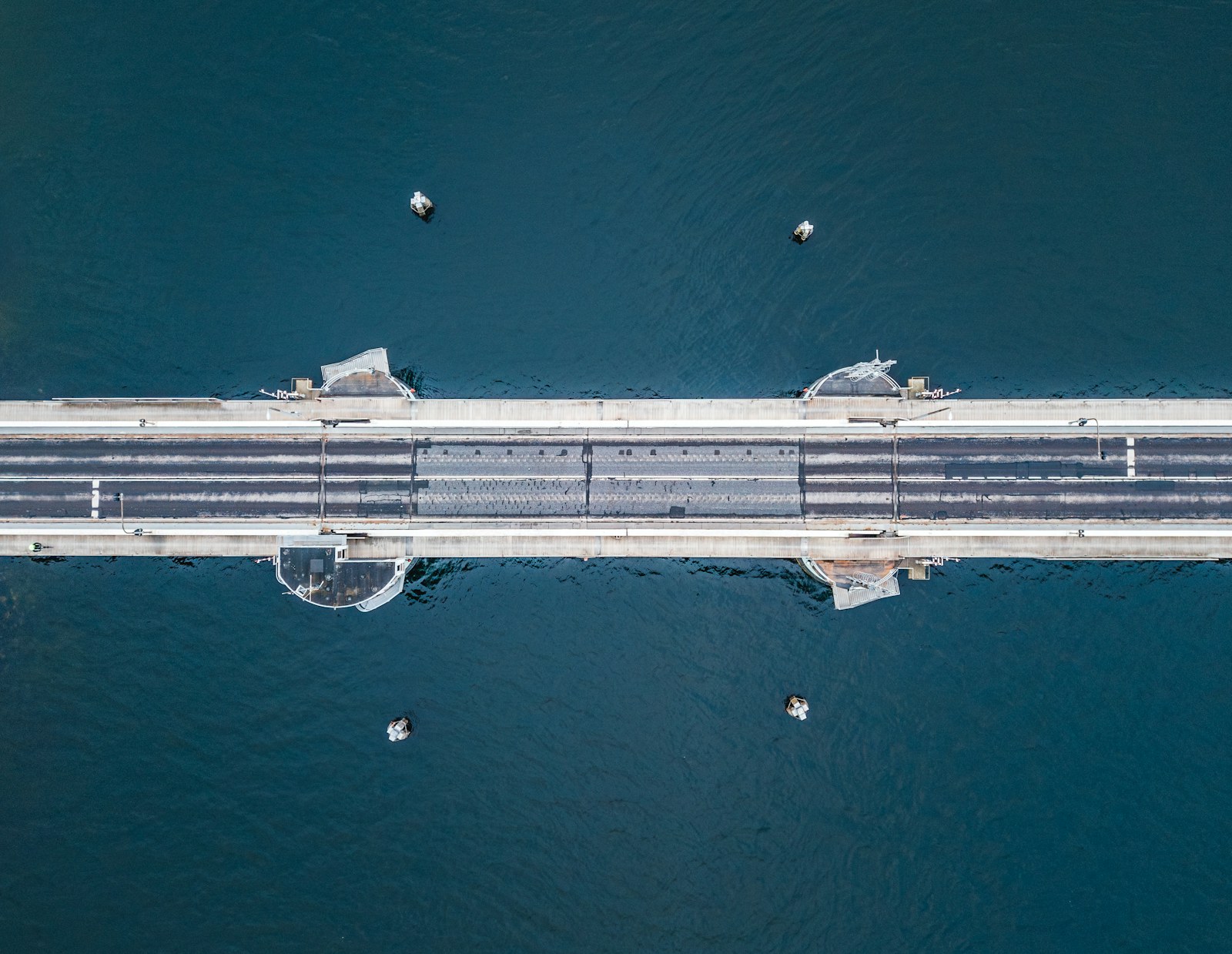 Aerial view of a bridge spanning deep blue water