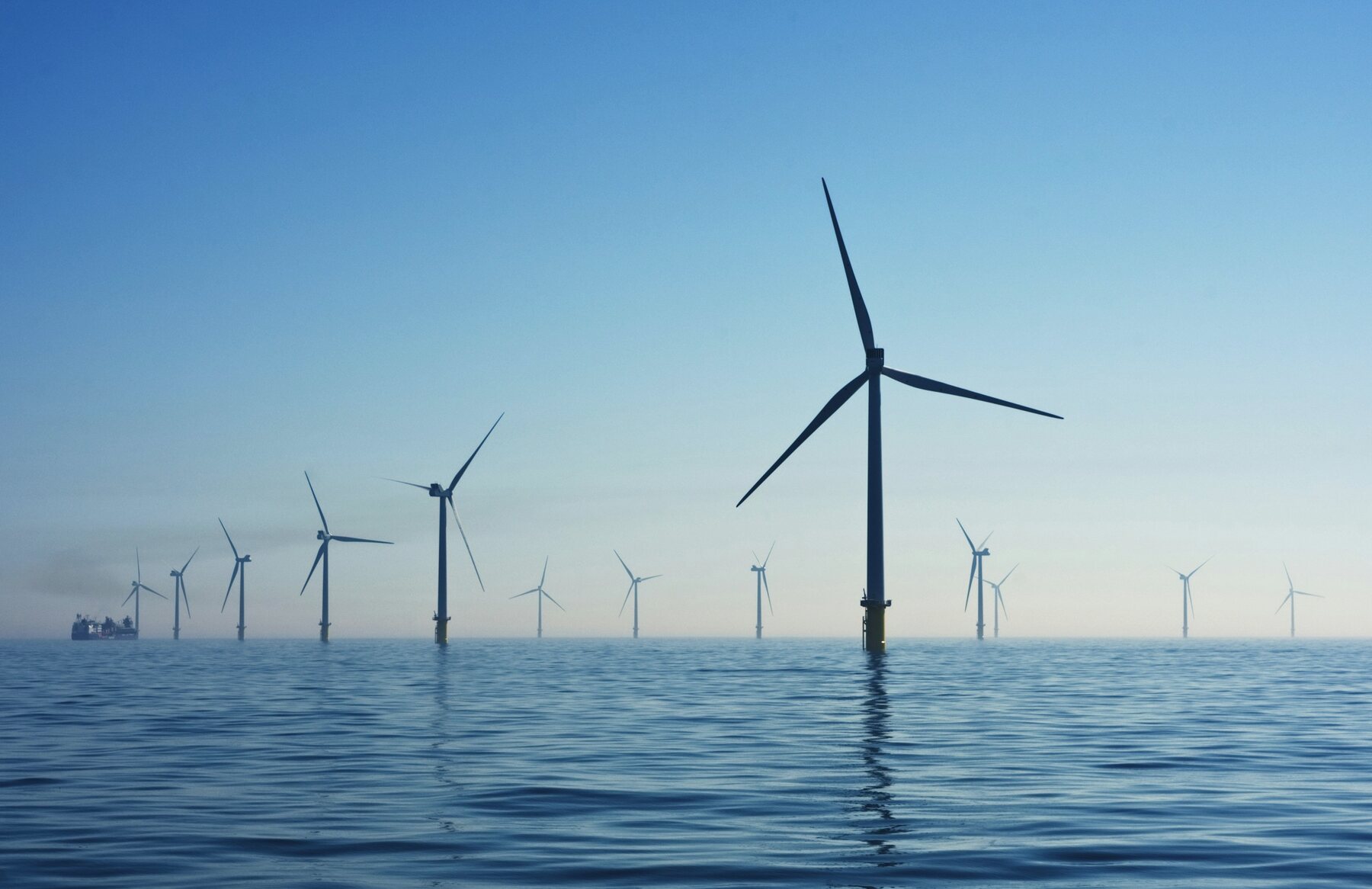 Offshore wind turbines extending across calm water