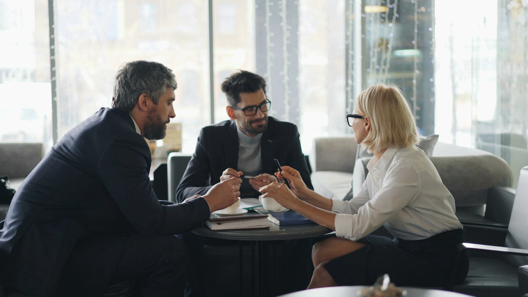 Three professionals discussing plans around a table