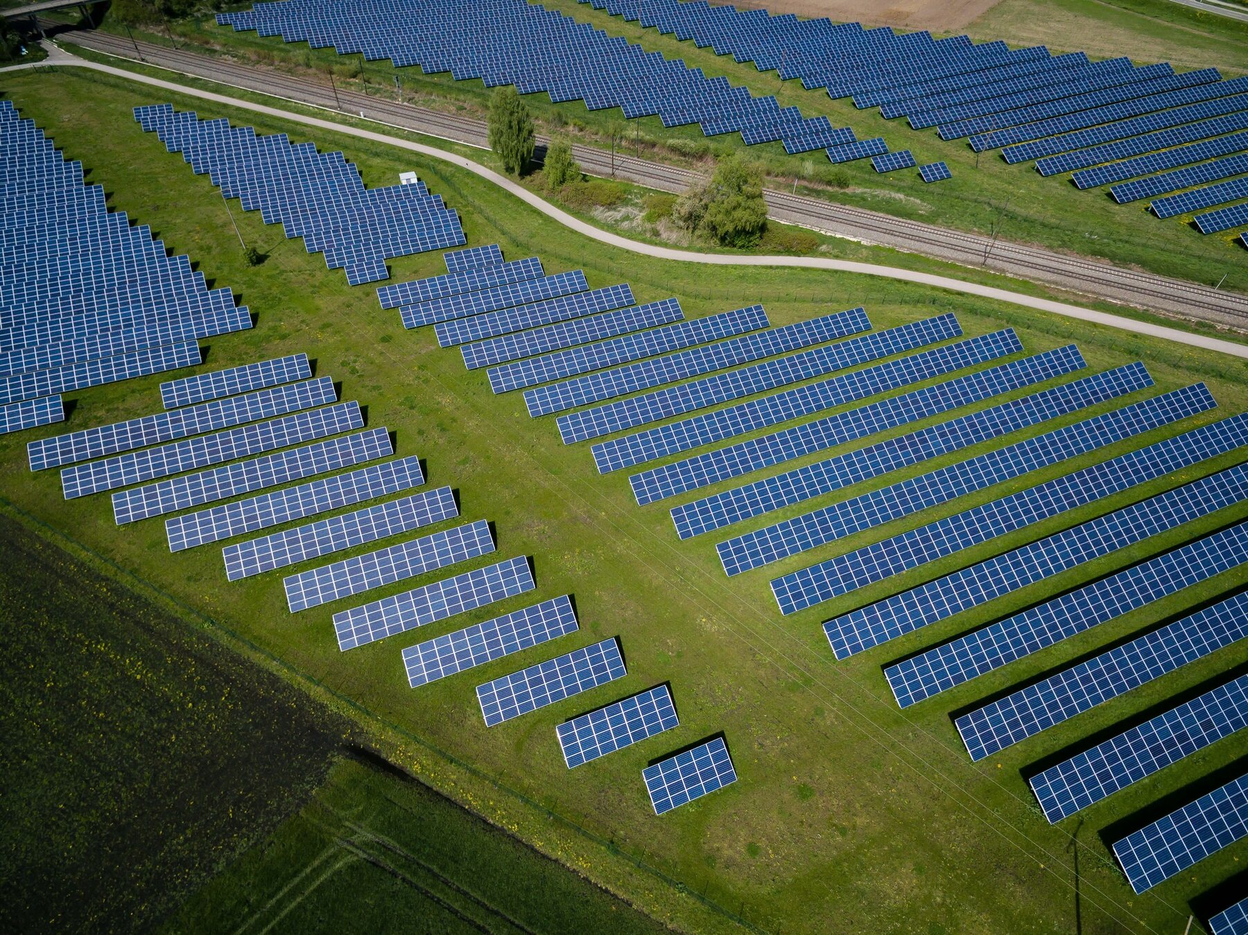 Rows of solar panels following the contours of green fields